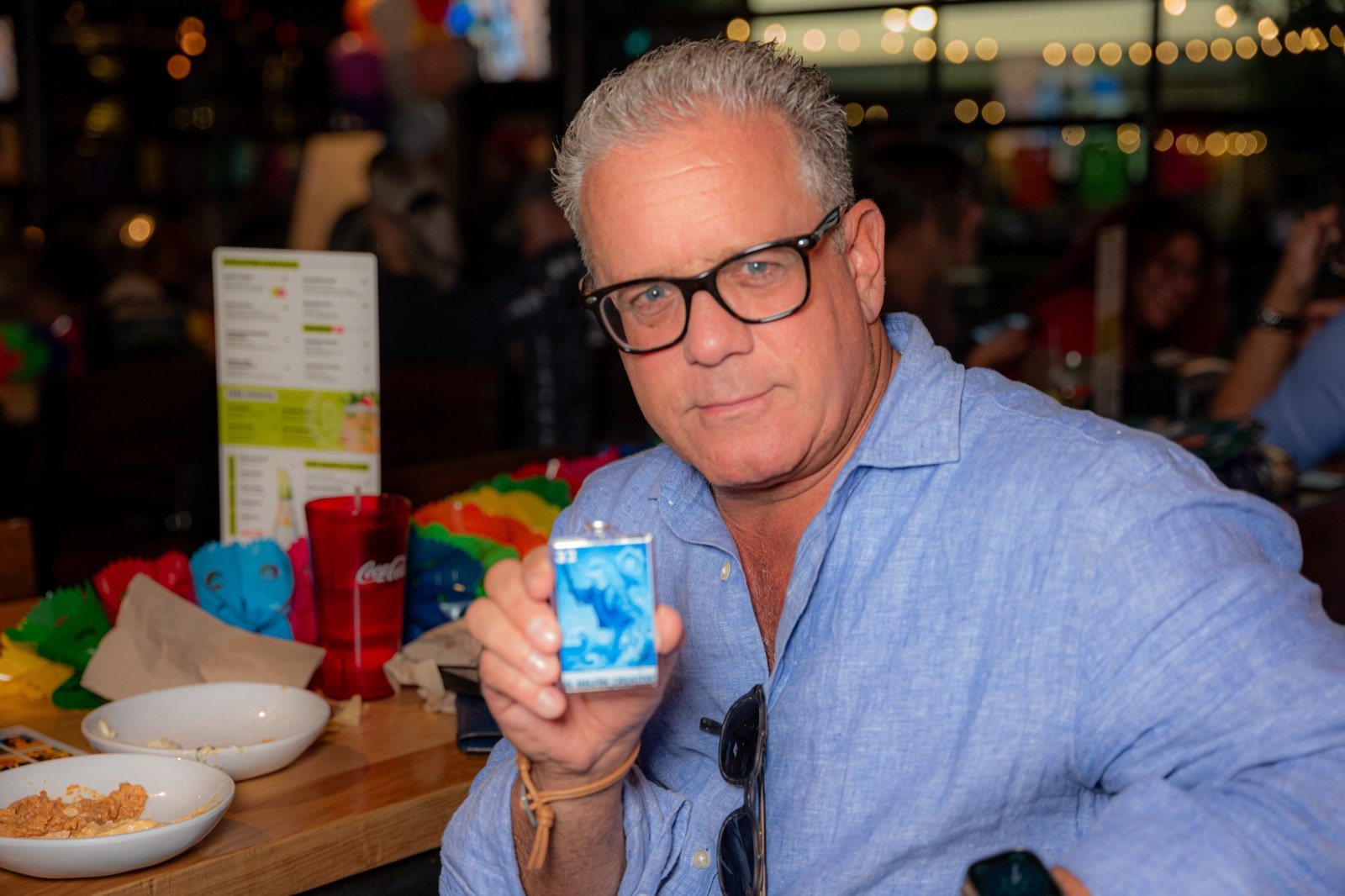 A guest holding up the El Delfín Creativo lotería card