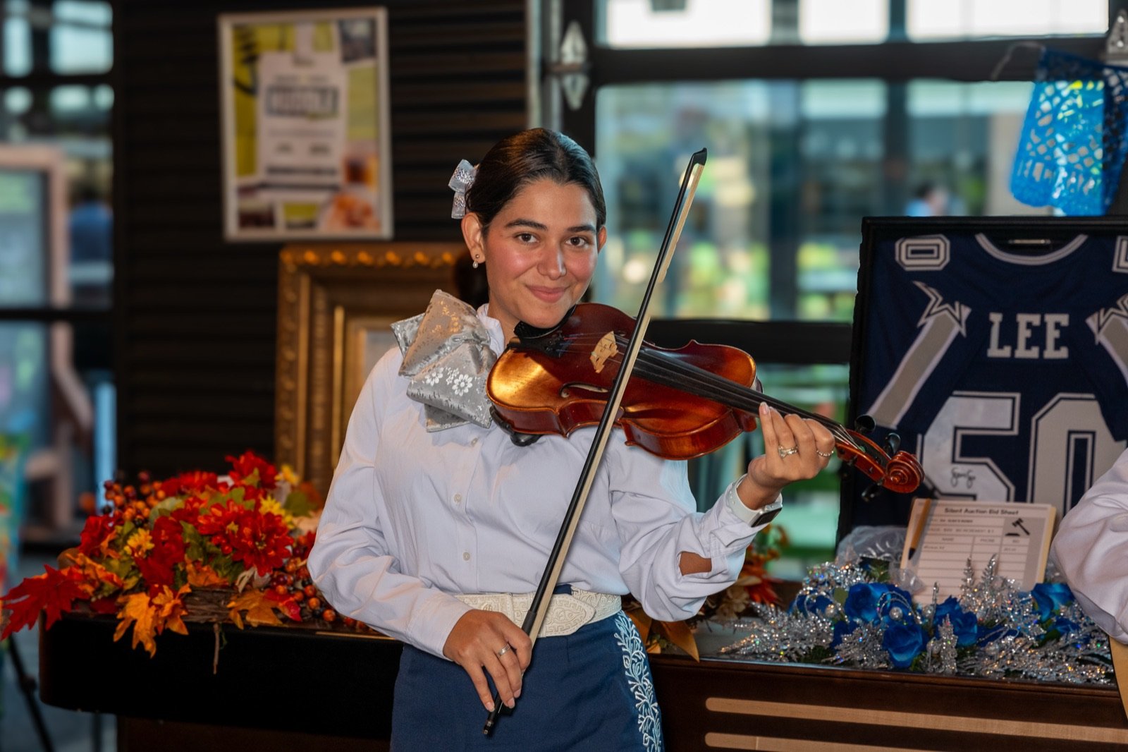 A mariachi violinist smiling mid-song