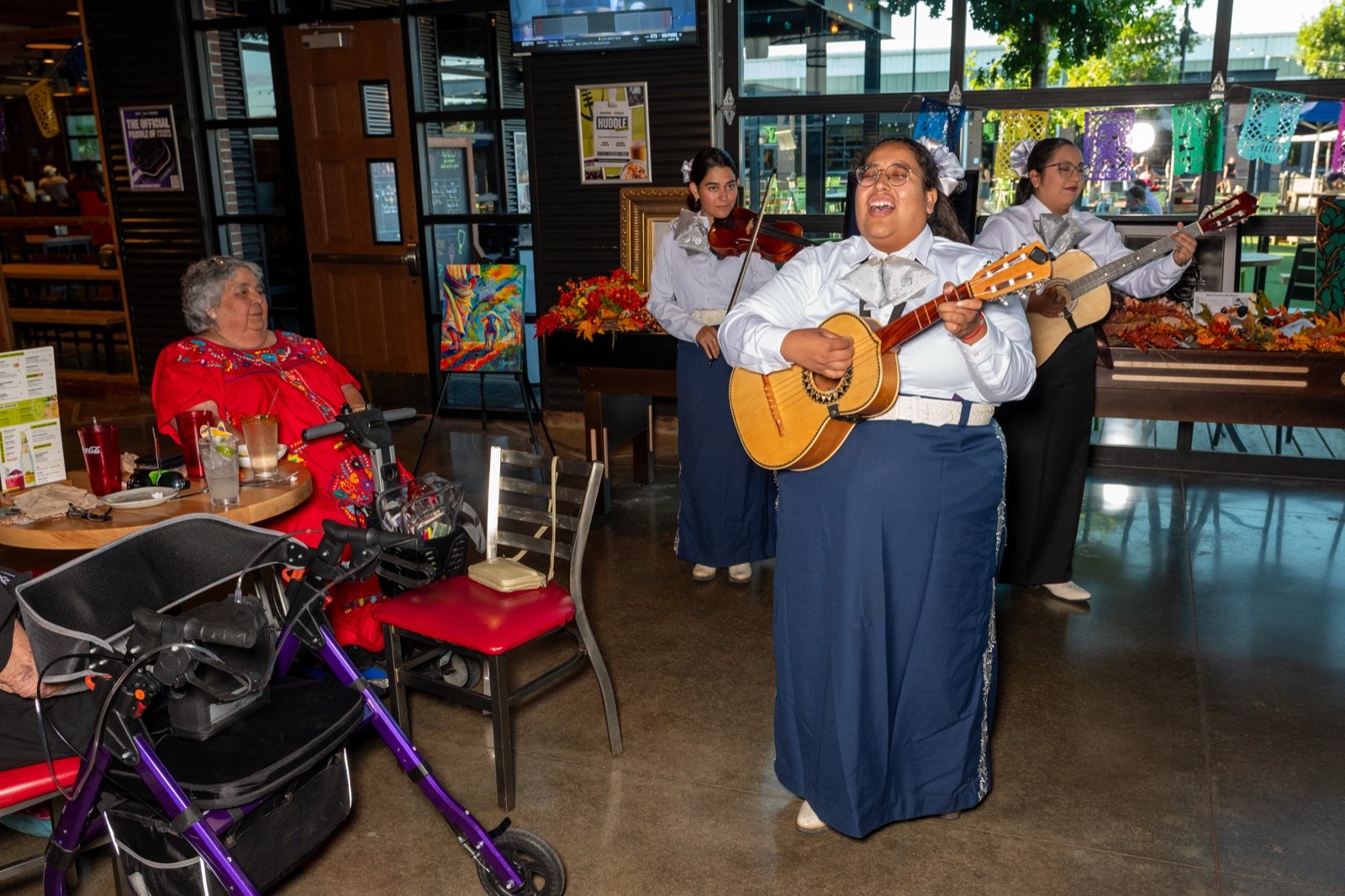 The mariachi trio serenading a guest at her table