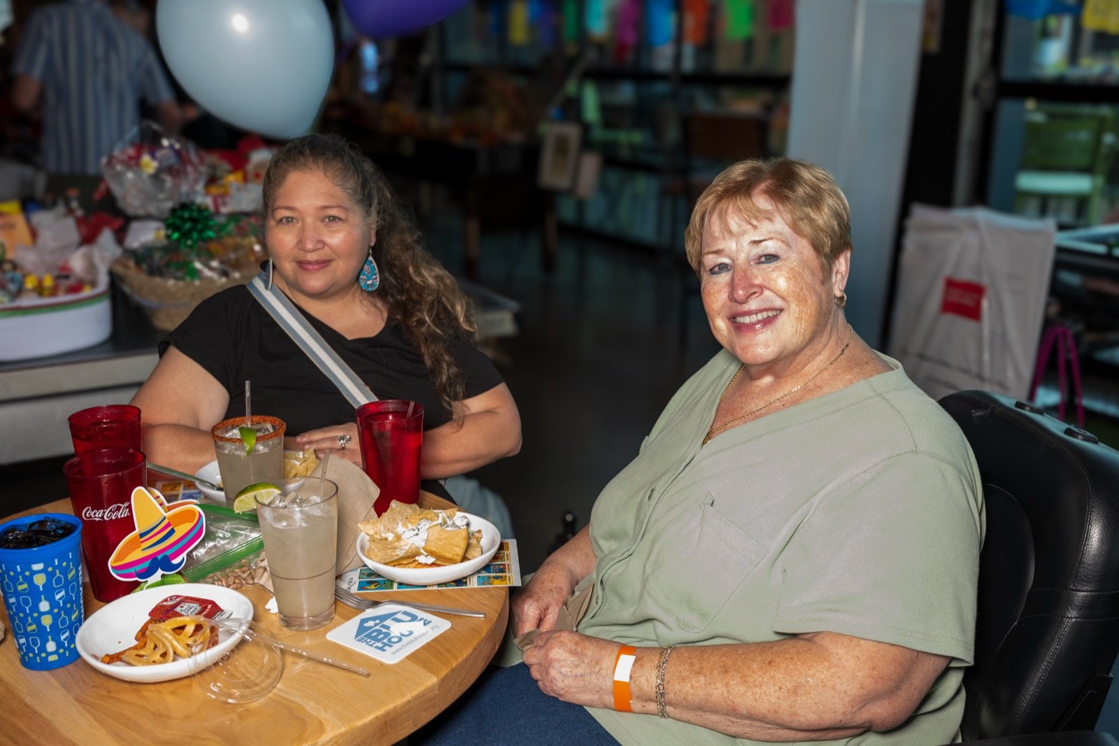 Two guests smiling at their table with a sombrero centerpiece