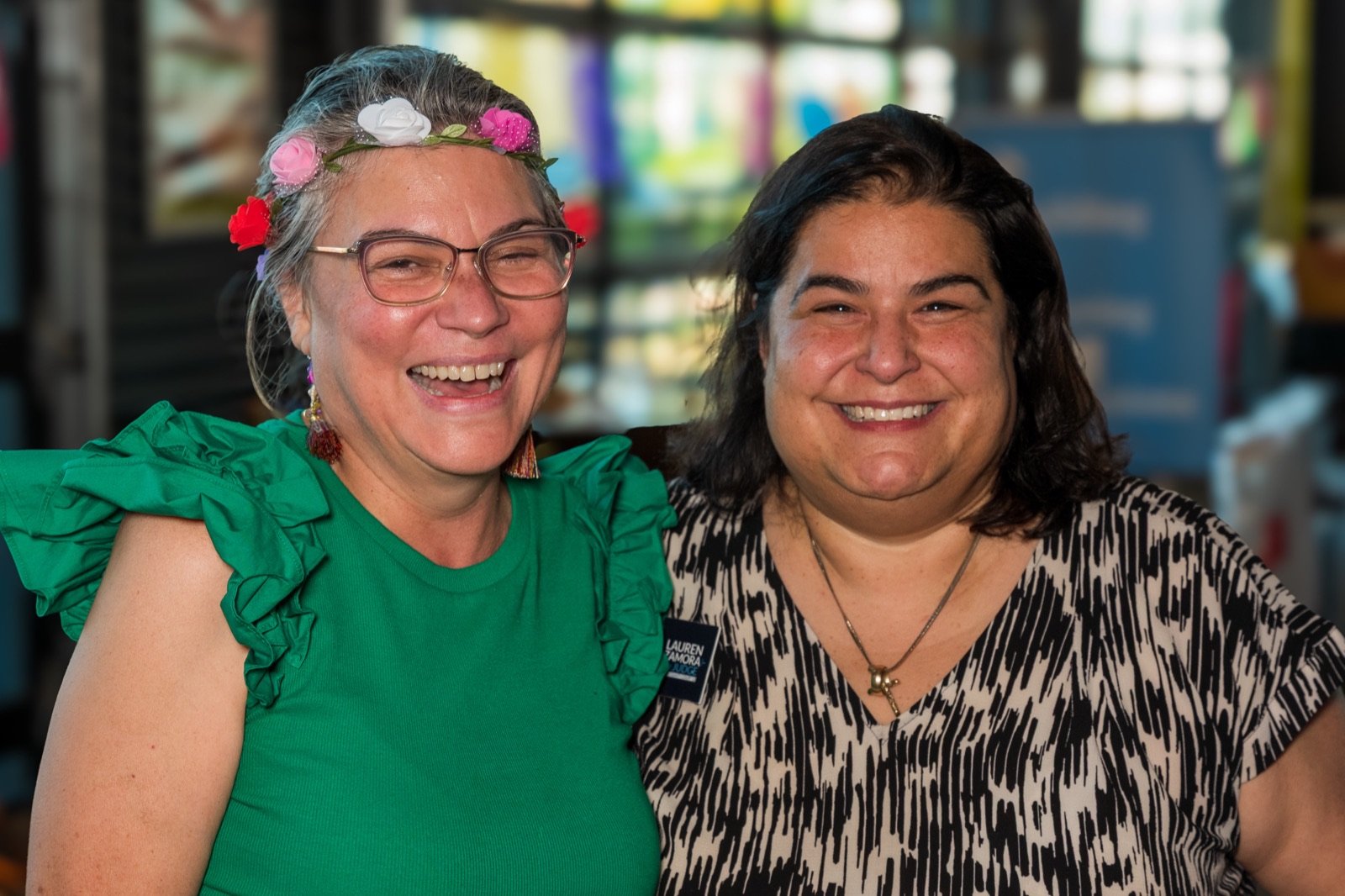 Two friends in flower crowns laughing together