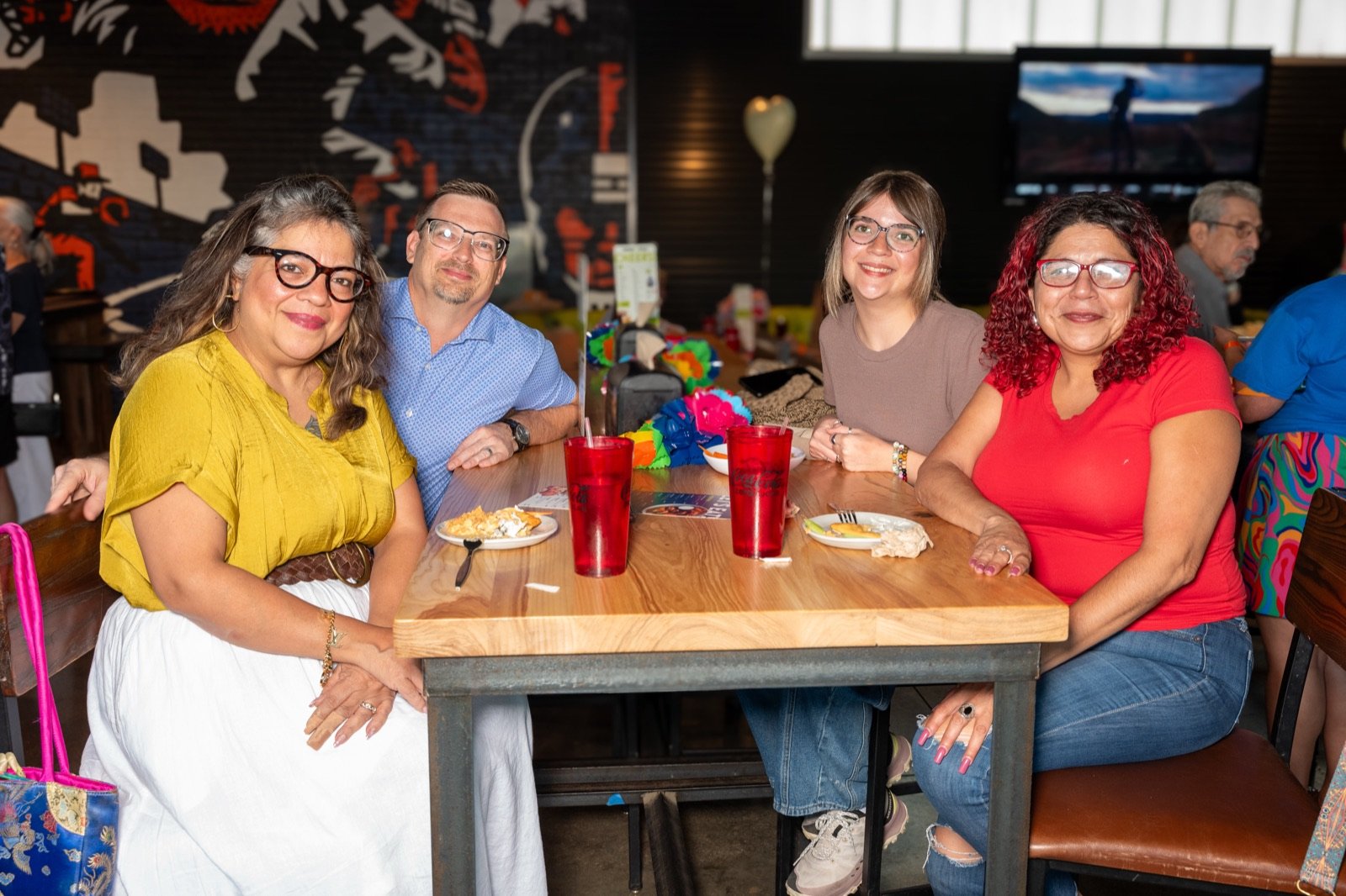 Four friends smiling around their table